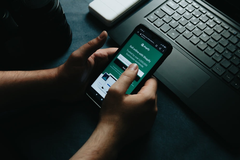 Person using Shopify on smartphone.